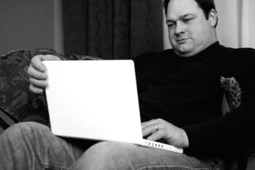 Man sitting with laptop open - WEB BW